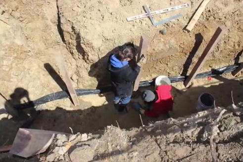 Der Graben bekommt einen Schlauch zur
                              Entw�sserung und Bel�ftung, und einige
                              Pfosten sind schon eingeschlagen 1