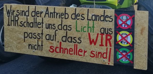 Demo der Bauern am 8.1.2024: Plakat:
                      Wir sind der Antrieb des Landes. IHR schaltet uns
                      das Licht aus. Passt auf, dass WIR nicht schneller
                      sind!