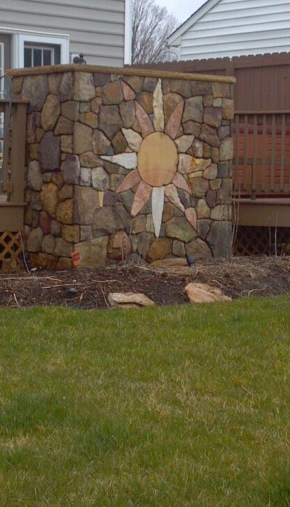 Trockenmauer-Kunst mit
                                          verschiedenen Steinen, eine
                                          Strahlensonne