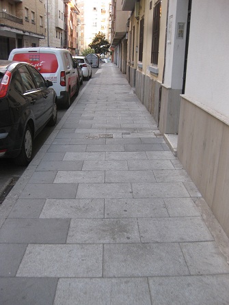 Trottoir /
                        B�rgersteig in weissen Platten mit schwarzem
                        Zahnrad-Rand