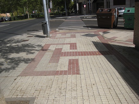 Trottoir / B�rgersteig in
                        gerillten, weissen Platten mit Mustern in roten,
                        gerillten Platten