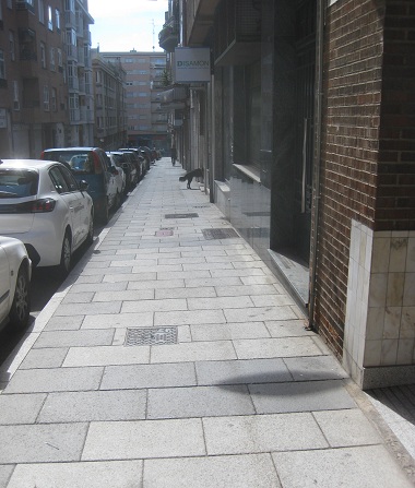 Trottoir in weissen Platten
                        mit schwarzem Zahnradrand