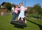 Tire swing 20 with a
                            bottom, the children upright on the swing,
                            preschool of Saint Vitus, Emertsham,
                            Bavaria, Germany