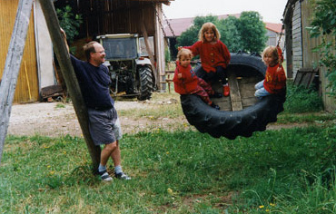 Reifenschaukel 18 mit
                            eingebautem Holzboden und mit
                            Antriebsperson, Ferienbauernhof Meyer in
                            Geslau, Franken, Deutschland.